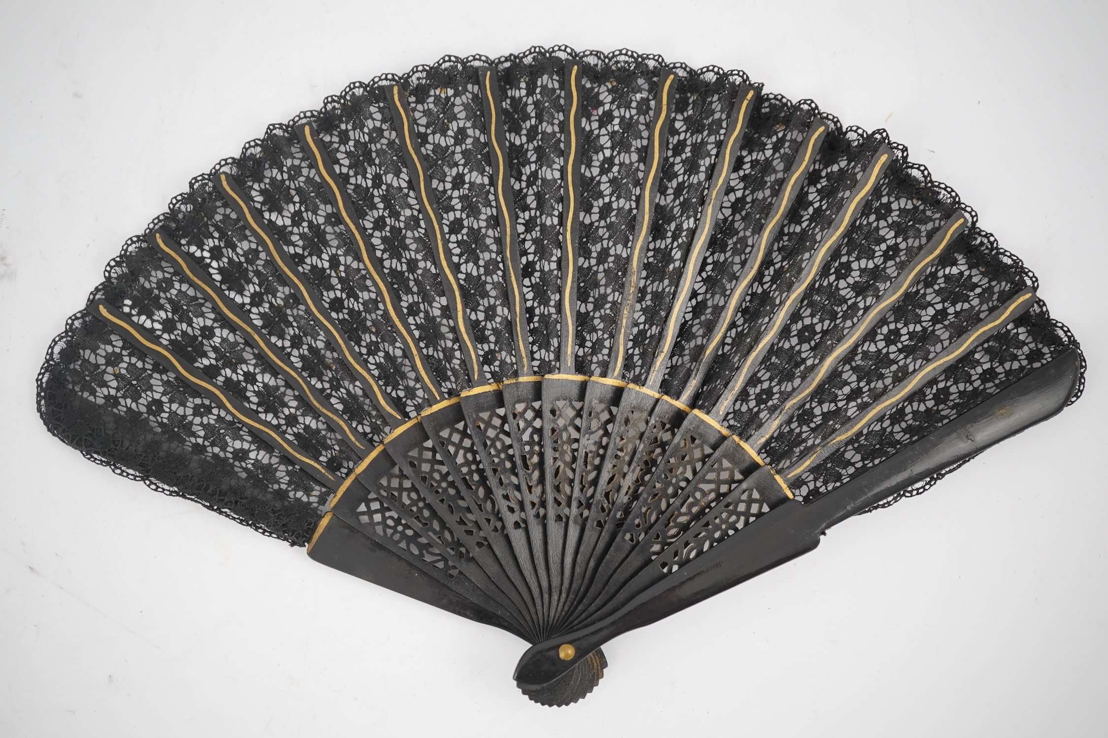 Three novelty fans with a mixed Brussels lace fan and black lace fan, a small language of love in flowers fan, a paper windmill advertising French Café fan, a carved cream Bakelite fan, a black and gilt, lace and sequin